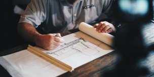 An architect working on a draft with a pencil and ruler