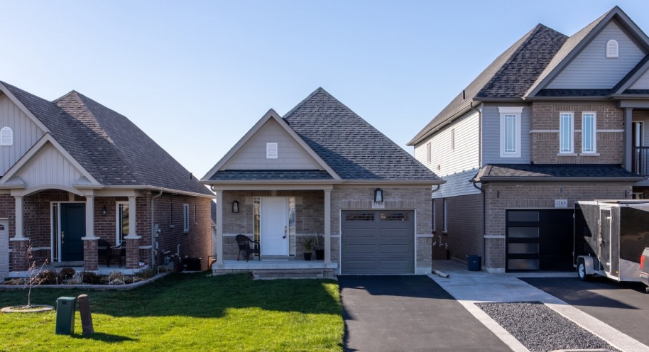 Small grey brick home in a subdivision.