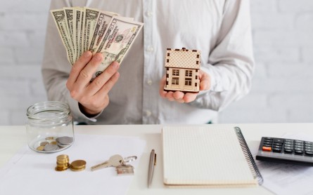 Realtor with money and wooden house