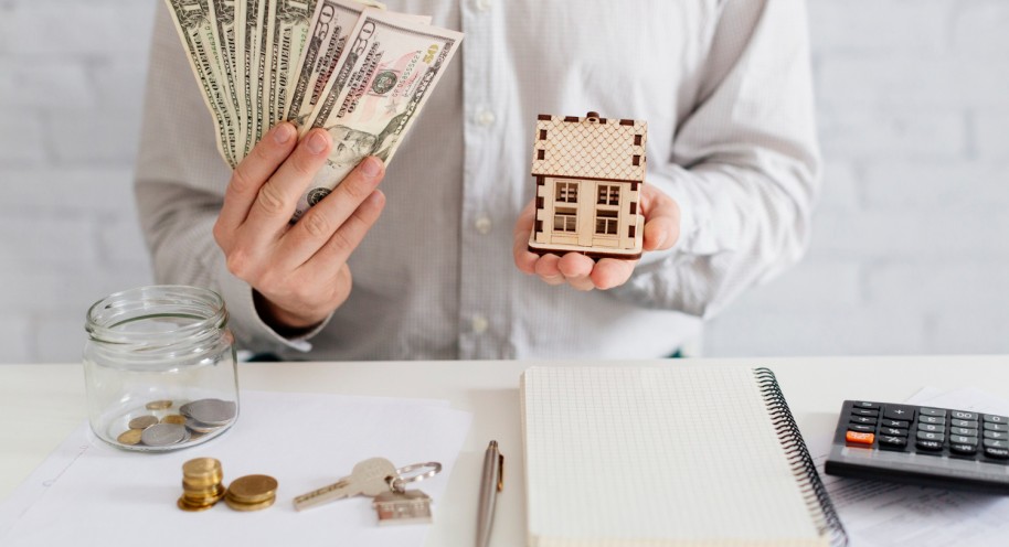 Realtor with money and wooden house