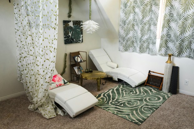 white and brown bed beside white and green floral curtain