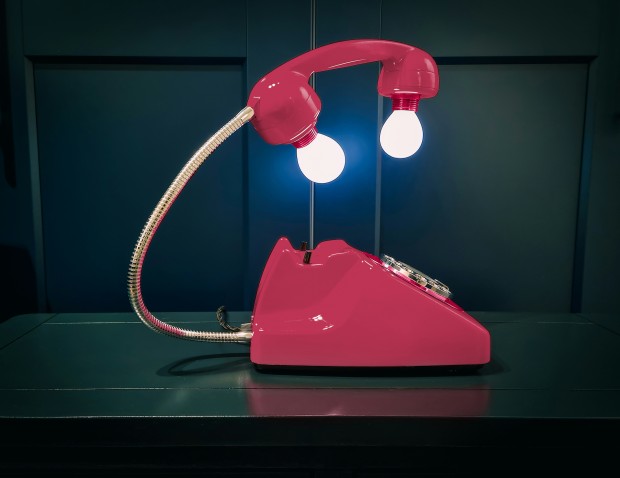 a pink telephone sitting on top of a table
